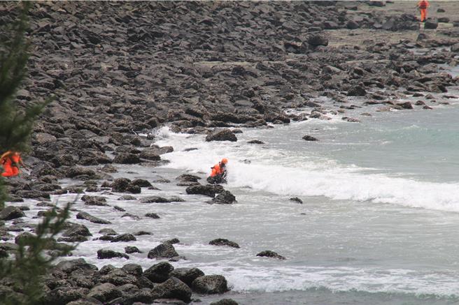 2024年7月28日澎湖县／新北游客28日梦幻沙滩戏水，1男惨遭海流带走寻获已溺毙。图为第一时间赶往的岸巡安检队员还在礁石区滑倒，甚至被浪拍打到站不住，但仍奋勇以双臂将溺者上半身撑离水面。（许逸民摄）