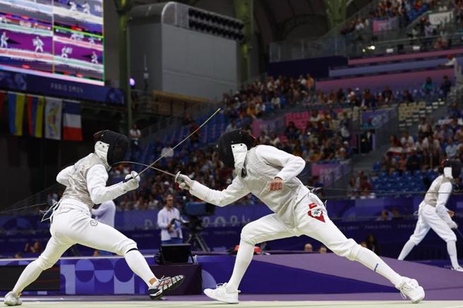 「击剑王子」陈弈通（左）以15比13击退黎巴嫩选手瓦金，晋级32强。（路透）