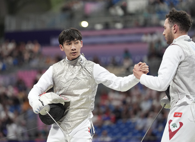 陈弈通（左）获胜后与黎巴嫩选手瓦金握手致意。（中华奥会提供）