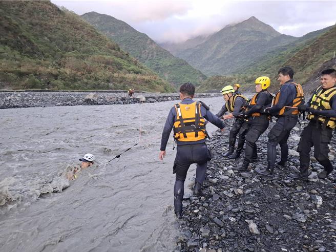 救援人員克服湍急的溪流，渡河營救受困男子。（屏東縣消防局提供／羅琦文屏東傳真）