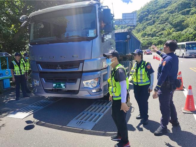 新北市警方29日在萬里區台2線玉田路口附近，架設活動地磅，攔查路過的大型車輛，加強取締。（金山警分局提供）
