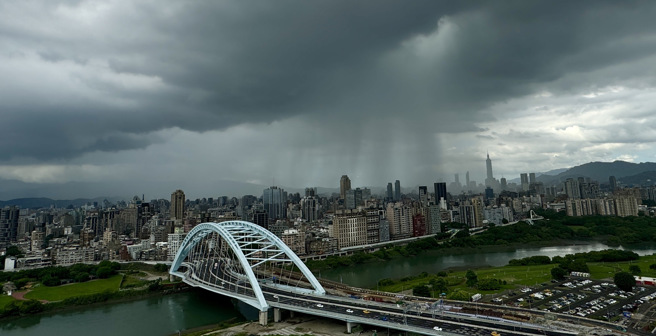 北市31日部分地区下起午后阵雨，天空中出现一道雨瀑般的黑色帘幕缓缓移动。（姚志平摄）