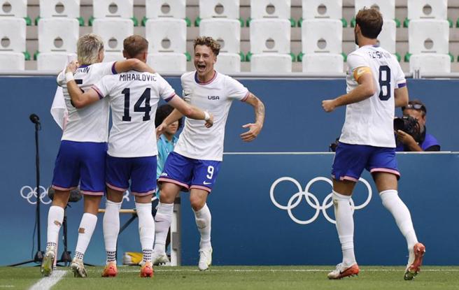 美国队米哈伊洛维奇（左二）射入直接自由球首开纪录，与队友拥抱庆祝。（路透）