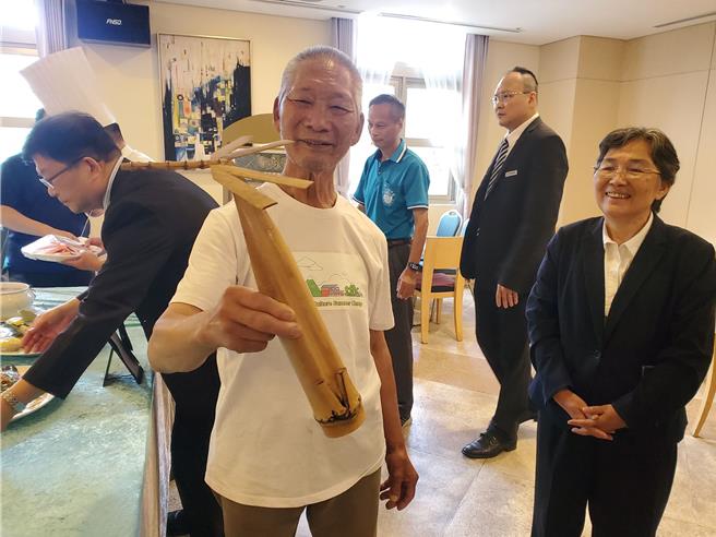 古坑乡草岭村石壁社区发展协会理事长郭守发是竹艺达人，他擅长做各式竹子物件，玩具如竹蜻蜓也很拿手，右为古坑乡长林慧如。（周丽兰摄）