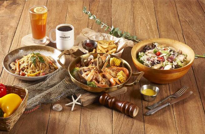 在新品牌「海岸線美式海鮮」餐廳點手抓海鮮盤，加購新鮮白蝦一磅188元。圖／業者提供