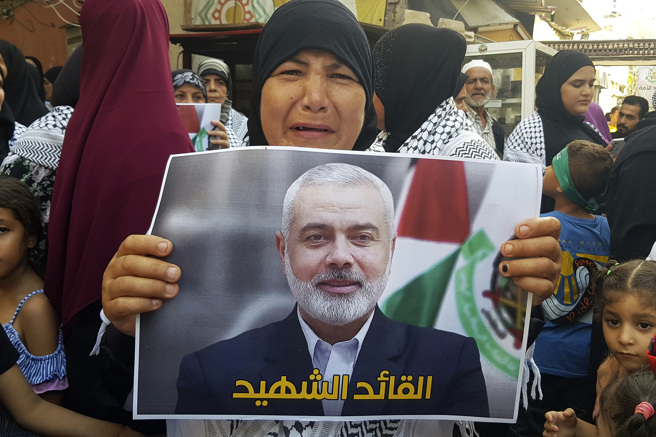 巴勒斯坦武裝組織「哈瑪斯」（Hamas）政治領袖哈尼雅（Ismail Haniyeh）周三在伊朗遇刺身亡，支持者31日拿著他的海報在黎巴嫩難民營抗議。（美聯社）
