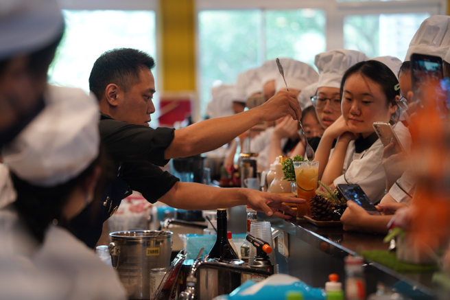 王建華老師現場示範調製台灣成年版黑糖珍珠奶茶，馬來西亞學生看得目瞪口呆。(照片/醒吾科大提供)