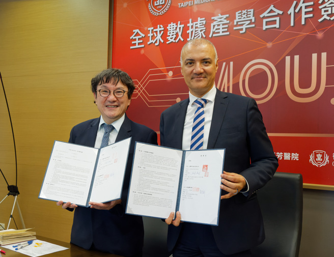 北醫大校長吳麥斯(左)與拜耳亞太區資深副總簽署合作備忘錄。（北醫大提供）