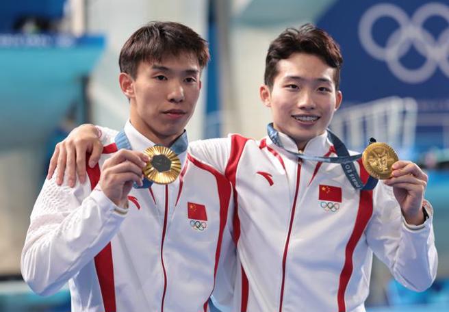 龙道一（左）、王宗源展示金牌。（中新社）