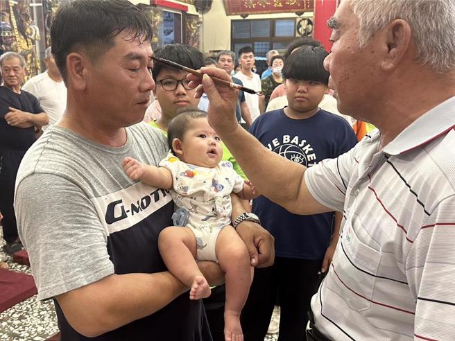 农历7月1日鬼门开，屏东县东港镇东南宫遵循古礼迎普渡公并为鸾生、信眾「点生做号」，保佑在鬼月时不受好兄弟干扰、祈求平安顺遂。（谢佳潾摄）