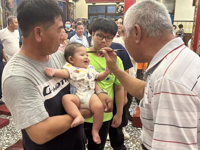 农历7月1日鬼门开，屏东县东港镇东南宫遵循古礼迎普渡公并为鸾生、信眾「点生做号」，保佑在鬼月时不受好兄弟干扰、祈求平安顺遂。（谢佳潾摄）