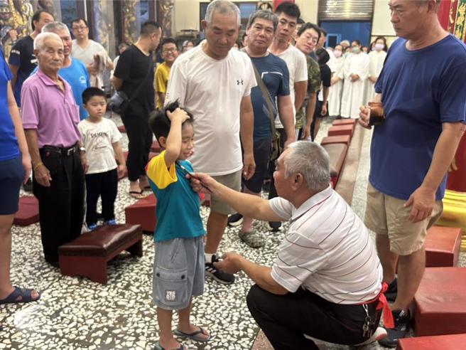 农历7月1日鬼门开，屏东县东港镇东南宫遵循古礼迎普渡公并为鸾生、信眾「点生做号」，保佑在鬼月时不受好兄弟干扰、祈求平安顺遂。（谢佳潾摄）