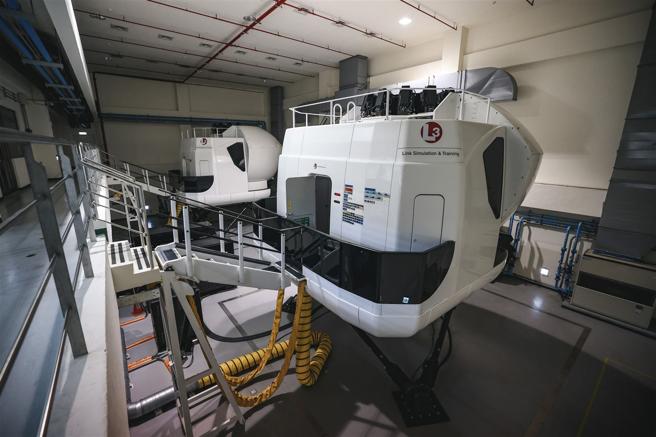 在实机飞行前，学员须完成模拟机操作训练，并从球体的座舱内，透过液压系统感受飞机的侧倾、俯仰等姿态，熟悉各项设备操作。（记者陈彦陵摄）