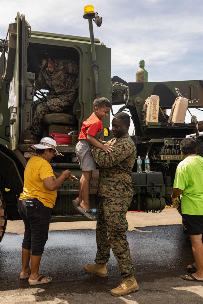 试乘体验后，美陆战队官兵亲切地协助孩童下车。（取自DVIDS网站）