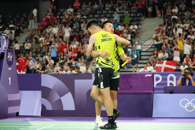 2024巴黎奥运2日举行羽球男子双打赛事，中华队李洋（后）、王齐麟（前）以18比21、21比17、21比10闯进金牌战，两人赛后合影留念。（杜宜谙摄）