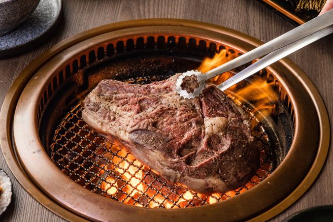 店內選用美國加州Brandt Beef自然牛超霸氣的大份量「戰斧牛排」，將整塊戰斧牛排霸氣上桌，佔滿烤盤後在最適當的炭火溫度下烤製，霸氣十足。（一牛楽提供）