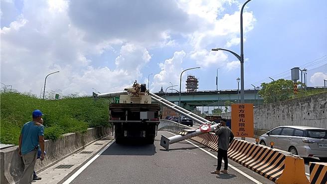 拖板车驾驶未注意限高，撞断路中限高架。（警方提供）