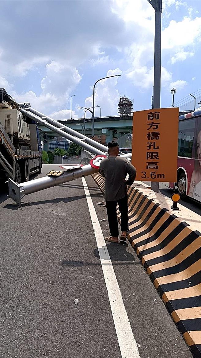 拖板车驾驶未注意限高，撞断路中限高架。（警方提供）