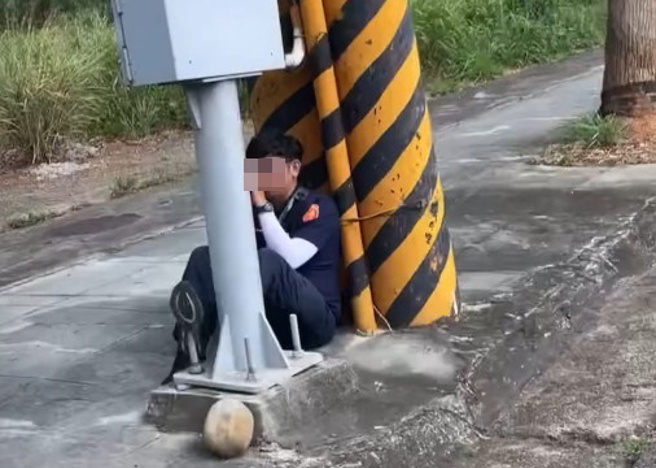 台中員警蹲坐在地上，依靠電線桿，手持手持式雷射測速槍取締超速違規車輛。（簡銘柱翻攝threads）
2024-7-22