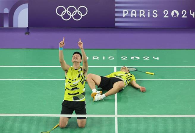 李洋／王齐麟在惊险击败大陆选手夺金后，李洋累翻倒地，王齐麟兴奋地跪在地上霜手指天，庆祝得来不易的金牌。（中时奥运採访团）