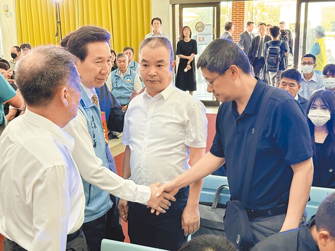 金門縣府在0214翻船事件中，居中扮演民進黨政府與陸方的溝通、傳話、潤滑的角色。圖為7月30日金門殯葬所為2名罹難的大陸漁民舉行公祭，金門縣長陳福海(左二)與陸方代表泉州市台港澳辦副主任李朝暉(右二)及海協會協調處長許偉偉(右一)握手致意。（于家麒攝）