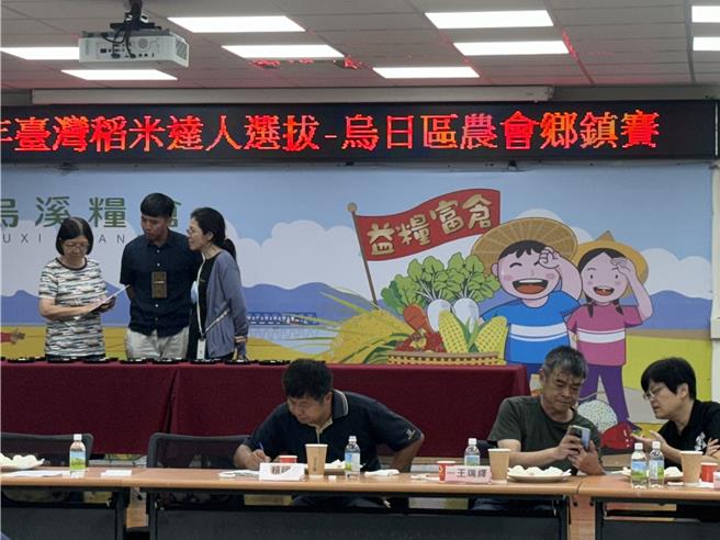 為鼓勵農友精進栽培技術並互相交流，台中市烏日區農會6日舉辦稻米競賽，評審委員現場細細查看稻米作品。（潘虹恩攝）
