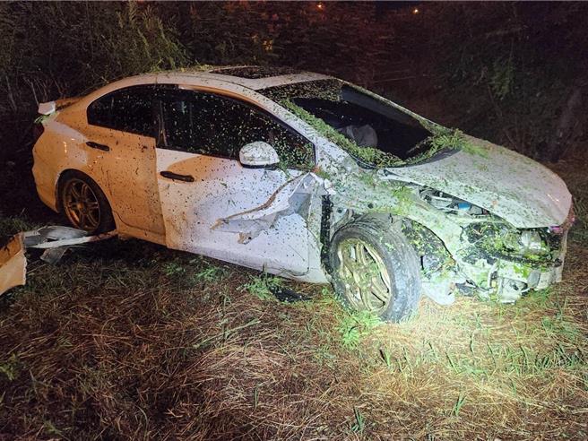 一輛自小客車6日深夜行經國道1號北向342.9公里高科路段，疑似因爲精神不濟撞擊出口匝道分向桿並衝至槽化線分隔島草叢內。（翻攝照片／林瑞益高雄傳真）