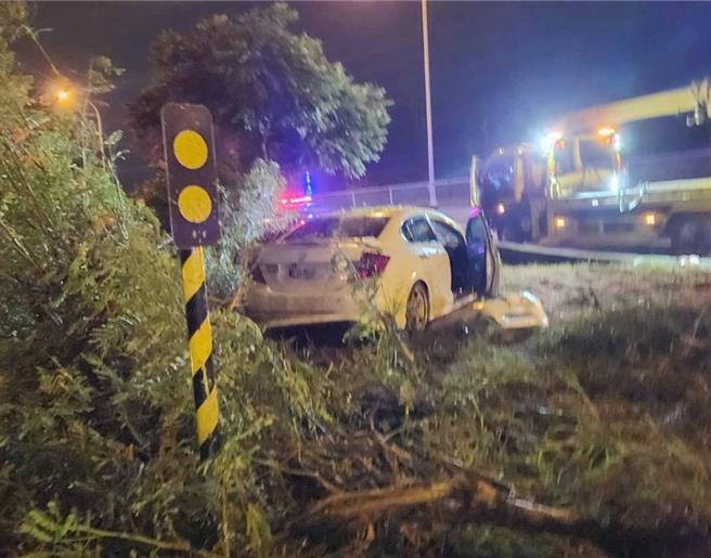 一輛自小客車6日深夜行經國道1號北向342.9公里高科路段，疑似因爲精神不濟撞擊出口匝道分向桿並衝至槽化線分隔島草叢內，圖為車禍現場。（翻攝照片／林瑞益高雄傳真）