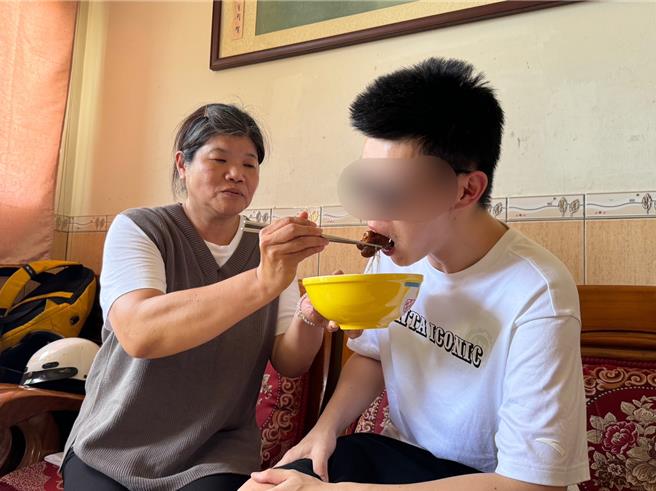 胡姓钓客(右)吃着家人准备的猪脚麵线感动的说，还是家的味道最好。(于家麒摄)