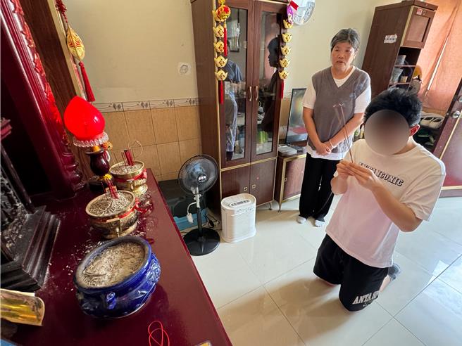 胡姓钓客(右)烧香禀明祖先已平安归来，一家人歷经4个多月的分离磨难，今天终于顺利团圆。(于家麒摄)