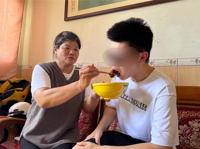 胡姓釣客(右)返回金門，吃著家人準備的豬腳麵線感動說，還是家的味道最好。(于家麒攝)