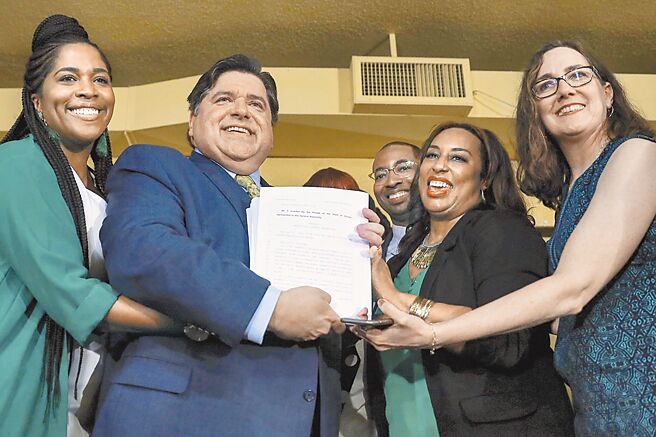 2019年6月25日伊利诺州州长J.B.Pritzker手持一项法案，宣示伊利诺州2020年起成人娱乐用大麻合法化。（美联社）