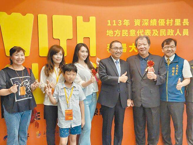「资深绩优村（里）长、地方民意代表及民政人员表扬大会」8日于新北市政府举办，土城区青云里长廖特青（右二）与民政局宗教科专员廖庭莹（右四）父女檔同时获奖，开心与市长侯友宜（右三）合影。（陈慰慈摄）