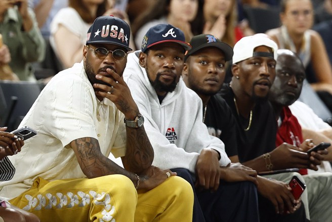 安森尼(左一)、杜蘭特(左二)與阿德巴約(右二)坐在場邊觀戰。(路透)