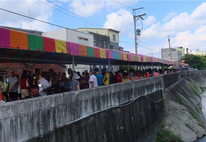 彰化縣田尾鄉北鎮、睦宜、新生等村村民，每年在農曆7月8日這天，都會舉行八堡圳祭，準備牲禮、鮮花、素果，沿著八堡圳岸邊擺桌普渡祭拜。（葉靜美攝）