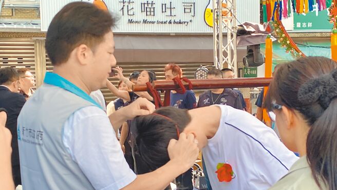 新竹市竹蓮寺遵循古禮每年舉辦七夕成年禮，祝福16歲青少年「轉大人」，代理市長邱臣遠（左）10日也到場見證「脫絭」儀式。（王惠慧攝）