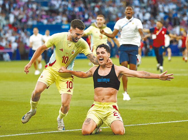 卡梅尤（下）在男足金牌戰延長賽補時階段攻入西班牙的第5球後，脫掉球衣跪滑慶祝。（路透）