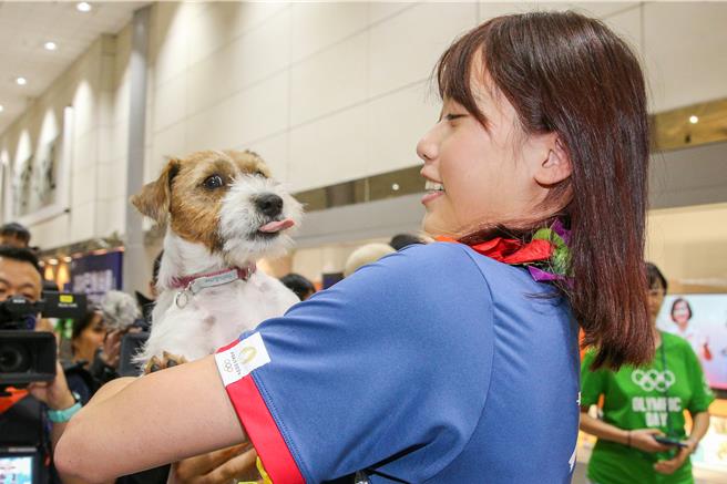 罗嘉翎的家人带着她的爱犬「欧巴」前来接机。（陈麒全摄）