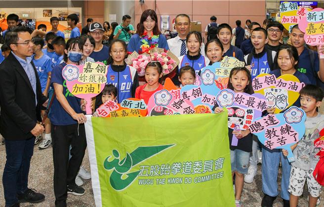 罗嘉翎（后排中）与接机小朋友合影。（陈麒全摄）