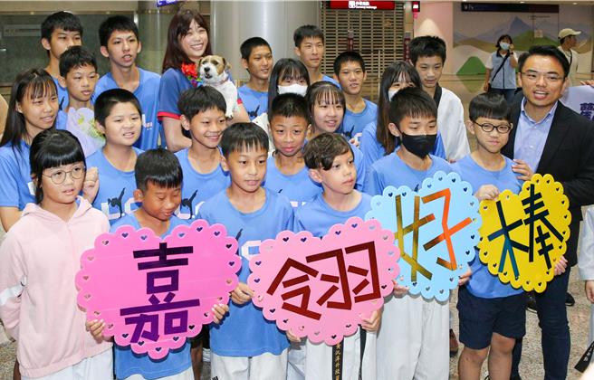 罗嘉翎（后排中）与接机小朋友合影。（陈麒全摄）