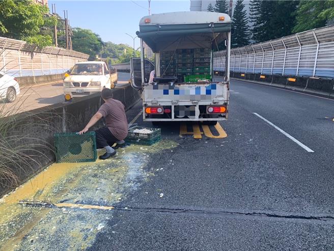因固定雞蛋的繩索斷裂，導致過彎時貨架2箱雞蛋掉於內側車道，上百顆雞蛋散落一地。（新店警分局提供）