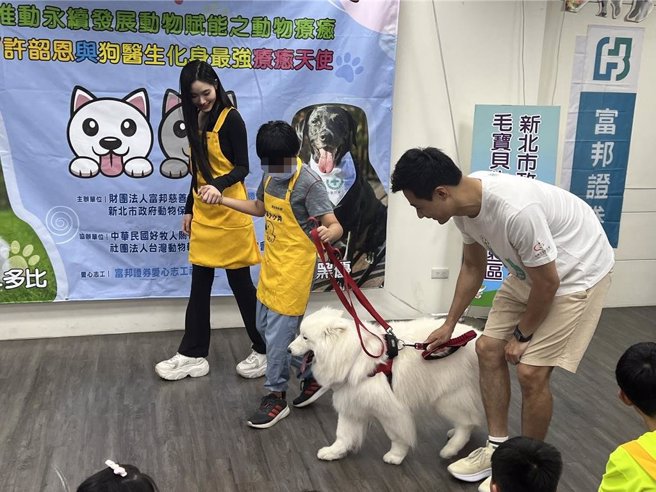 許韶恩（左一）與狗醫生「多比」一起和慢飛天使互動。（王揚傑攝）