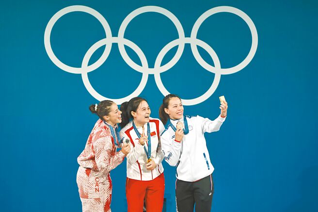 奥运场上出现许多两岸运动员同框的友好互动。图为举重女神郭婞淳（右起）8日与大陆选手罗诗芳和加拿大沙朗灿笑自拍。（本报资料照片）