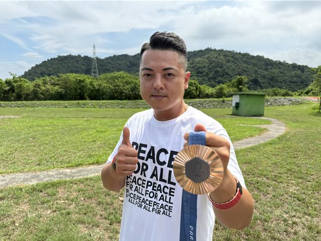 李孟远13日回训练母基地宜兰大同乡四方林靶场，与射击前辈们分享夺牌喜悦。（吴佩蓉摄）