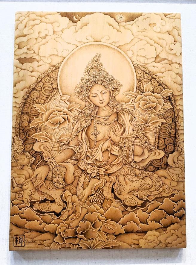 顏麗梅的烙畫作品「綠度母」，融合慈悲與美麗，精準傳達綠度母意涵。（周麗蘭攝）