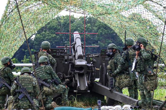 炮班人员在教官下达毒气状况后，迅速戴上防护面具，继续完成射击任务，临危不乱。（记者简廷哲摄）