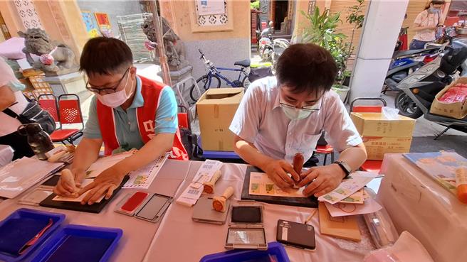 台南邮局16日在郑成功祖庙前设置临时邮局，发行郑成功纪念邮票，现场有邮务人员提供加盖邮局戳章服务。（程炳璋摄）