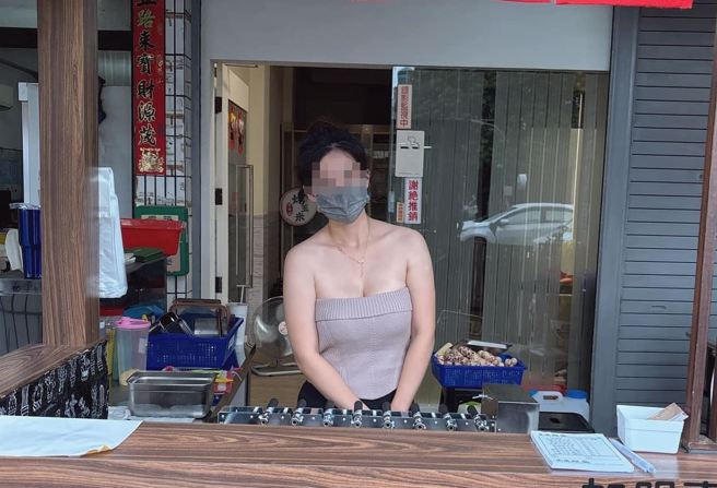 高雄在地烤玉米摊位板娘穿着无肩上衣，露出雄伟上围准备替客人烤玉米。（图／翻摄自脸书高雄揪出游）