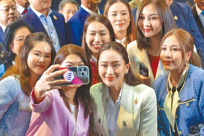 泰国新任总理贝东塔（中）16日与为泰党成员合影留念。（美联社）