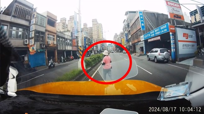 大妈违规穿越马路还不看来车，险遭小黄撞上，没想到大妈手上抱的商品，竟然是偷来的。（翻摄爆料公社）